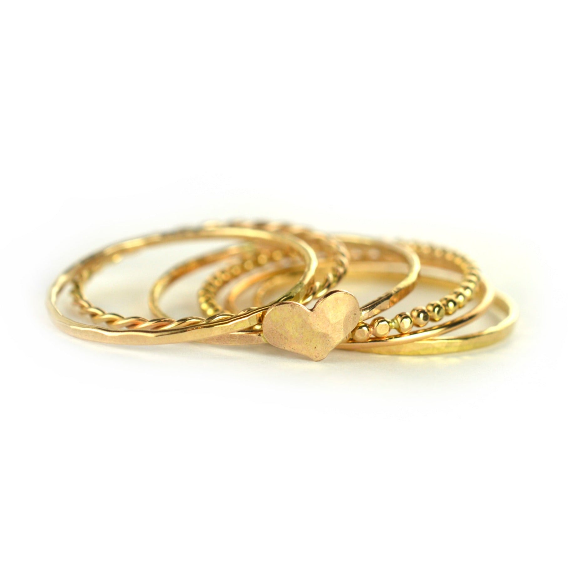 One of a kind gold hammered heart stacking ring set made of a variety of ring styles.